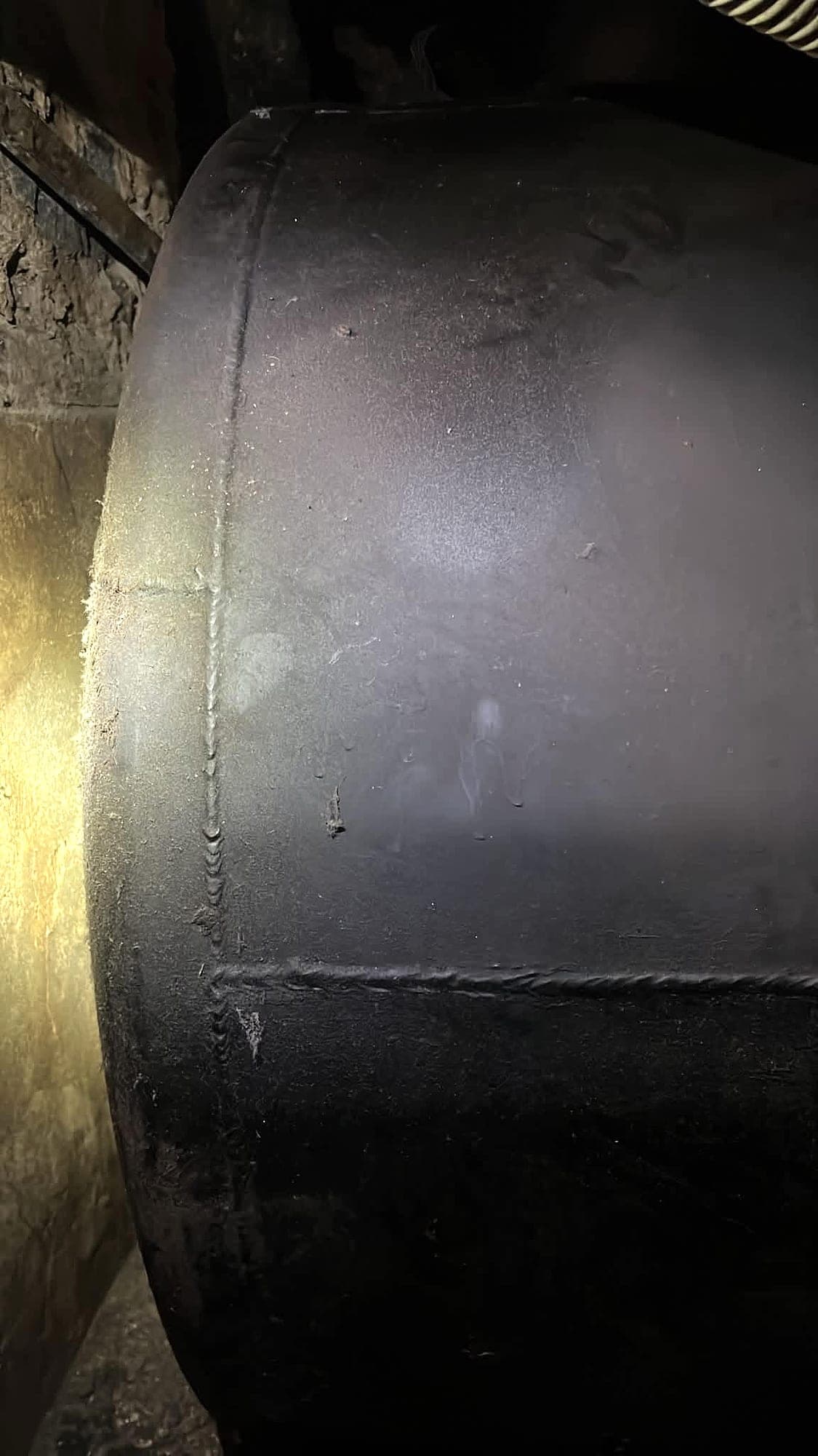 Flanc d'une cuve cylindrique en acier installée dans une cave
